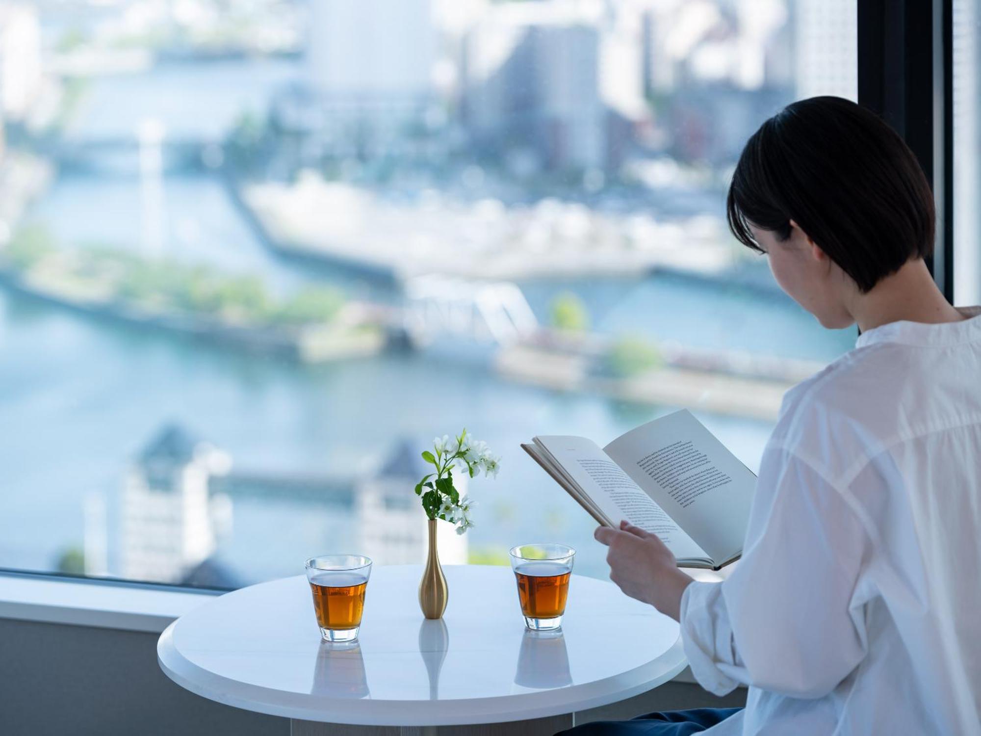Mitsui Garden Hotel Yokohama Minatomirai Premier Bagian luar foto A woman reading a book